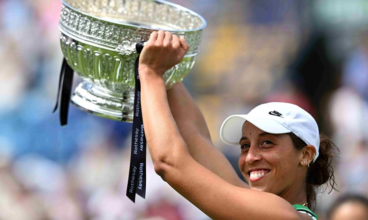 Madison Keys lifting the Eastbourne trophy above her head on court in celebration