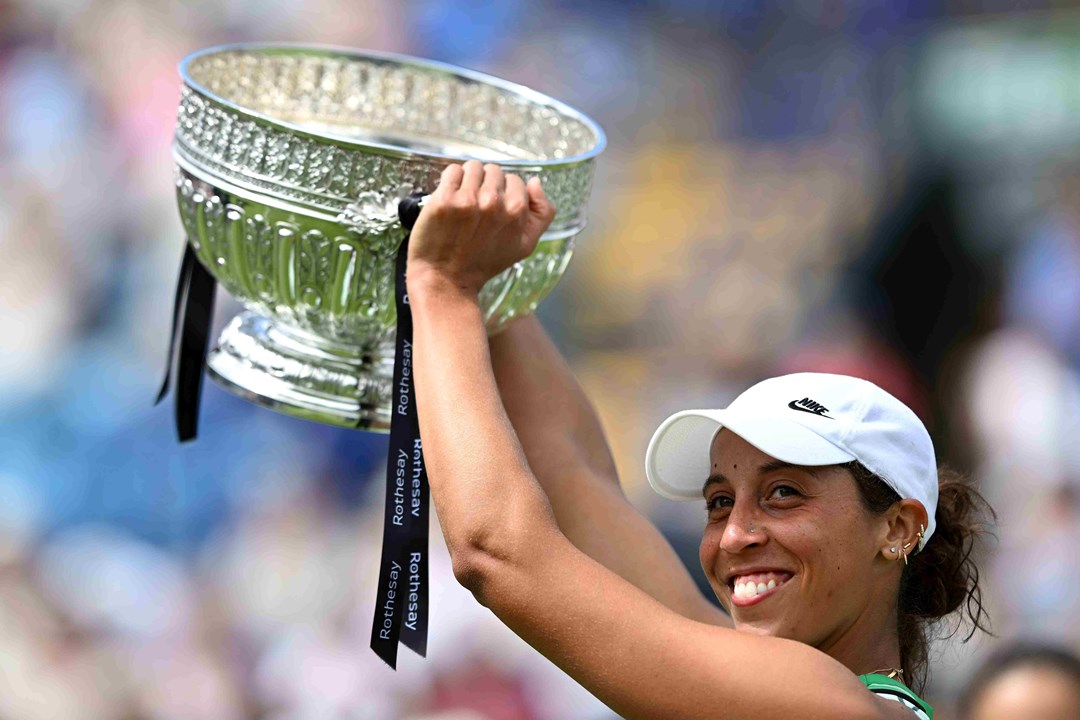 Madison Keys lifting the Eastbourne trophy above her head on court in celebration