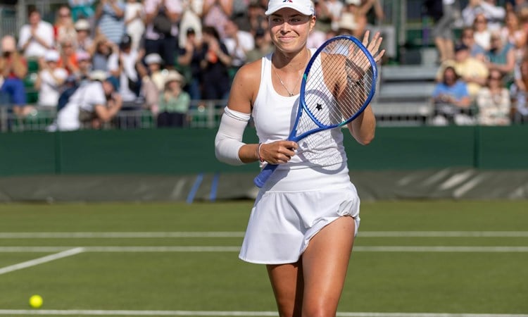 Emily Appleton clapping her racket after winning in the first round at Wimbledon qualifying
