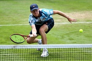Luke Johnson bends down to hit a volley at the Rothesay International Eastbourne