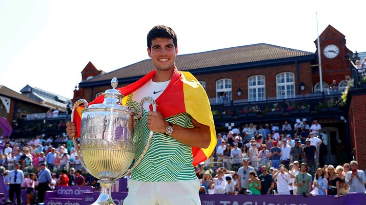 cinch Championships 2023 winner Carlos Alcaraz stood holding his trophy on court with the Spanish flag draped around his shoulders