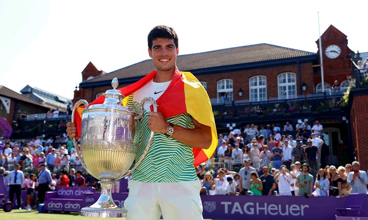 cinch Championships 2023 winner Carlos Alcaraz stood holding his trophy on court with the Spanish flag draped around his shoulders