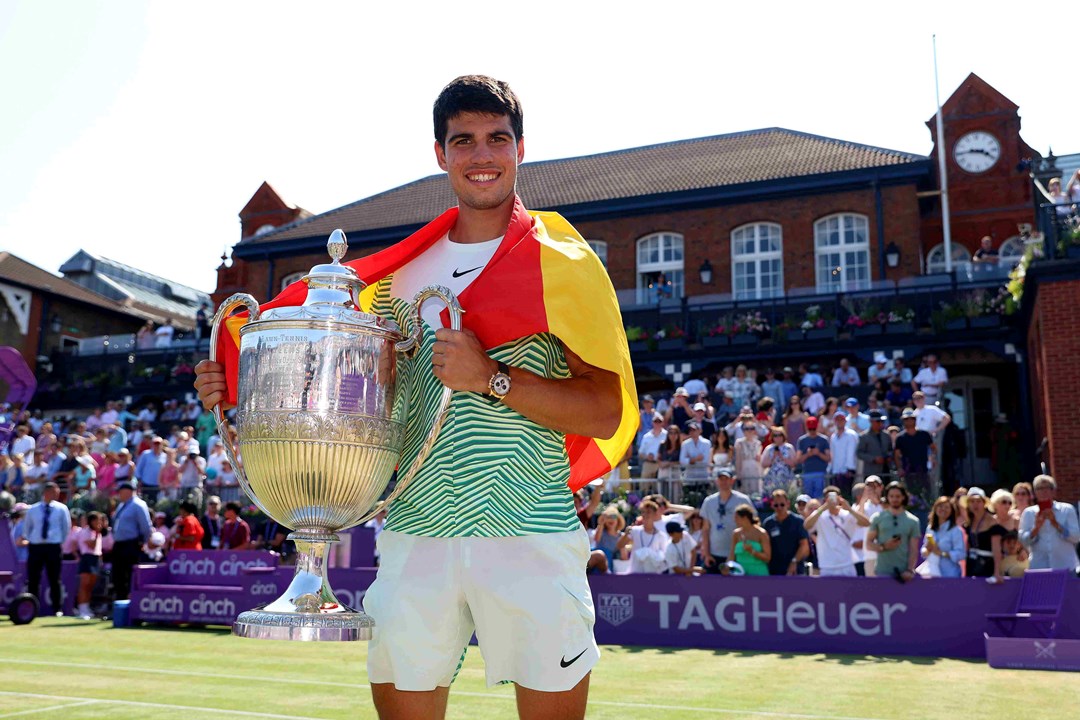 cinch Championships 2023 winner Carlos Alcaraz stood holding his trophy on court with the Spanish flag draped around his shoulders