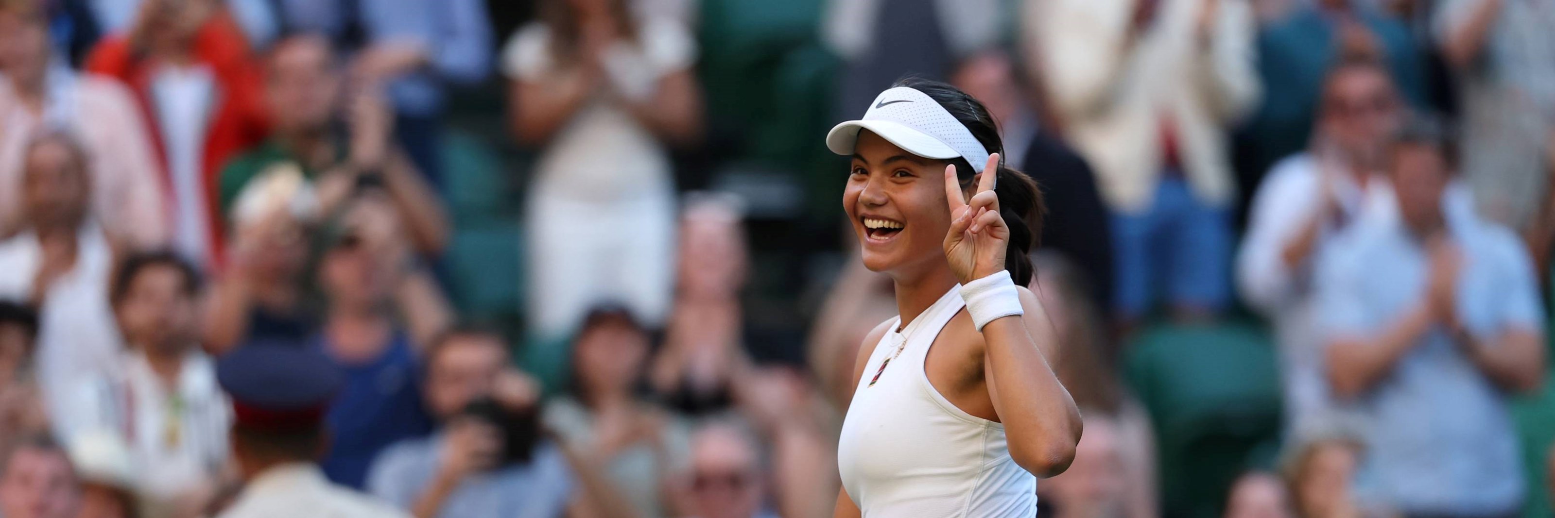 Emma Raducanu holds up the peace sign after a second round win at Wimbledon 2025