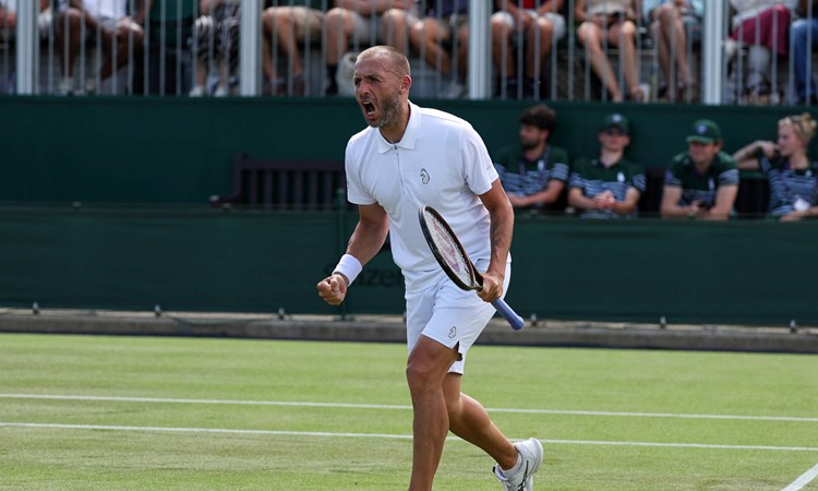 Dan Evans holding his tennis racket in his hand and screaming after winning a game at Wimbledon against fellow Brit Jay Clarke