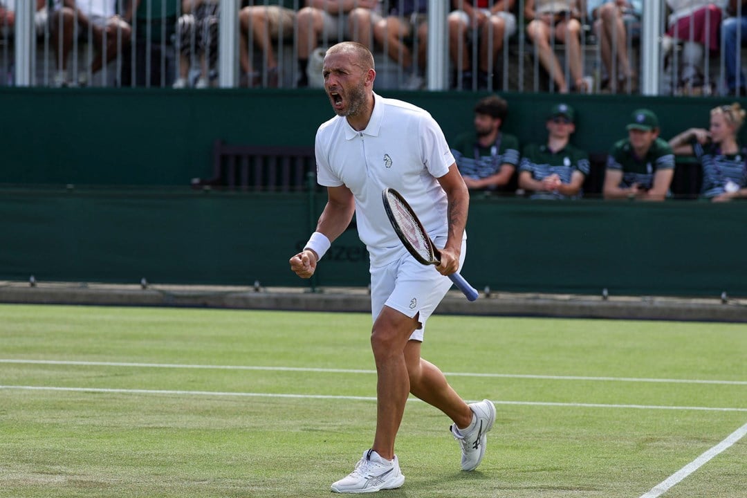 Dan Evans holding his tennis racket in his hand and screaming after winning a game at Wimbledon against fellow Brit Jay Clarke