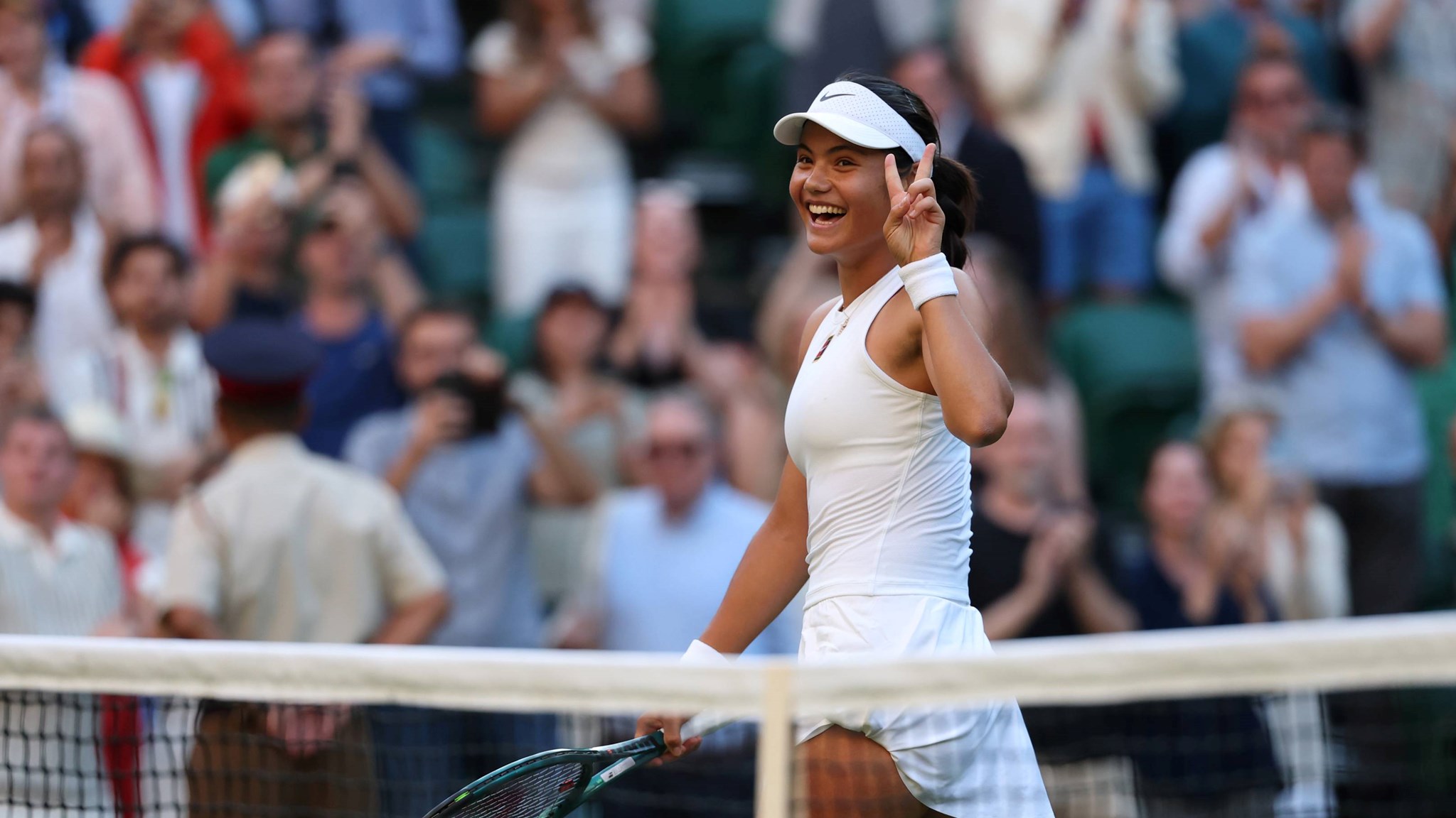Emma Raducanu holds up the peace sign after a second round win at Wimbledon 2025