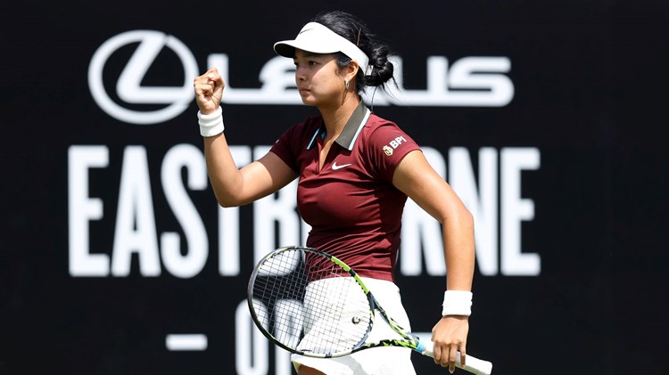 Alexandra Eala clenching her fist in celebrating and holding her racket on court at the Lexus Eastbourne Open