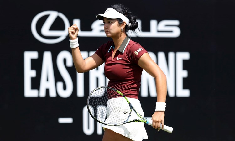 Alexandra Eala clenching her fist in celebrating and holding her racket on court at the Lexus Eastbourne Open