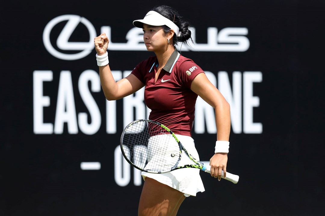 Alexandra Eala clenching her fist in celebrating and holding her racket on court at the Lexus Eastbourne Open