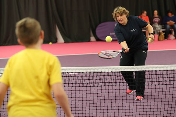 Coach hitting a foam ball to a junior player