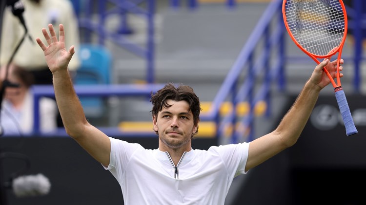 Taylor Fritz holding his hands up in the air and waving to fans on court at the Lexus Eastbourne Open