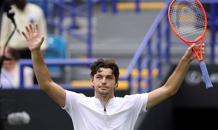 Taylor Fritz holding his hands up in the air and waving to fans on court at the Lexus Eastbourne Open