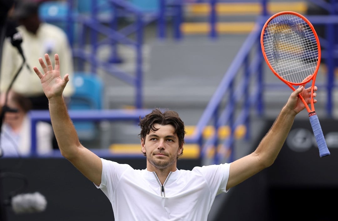 Taylor Fritz holding his hands up in the air and waving to fans on court at the Lexus Eastbourne Open