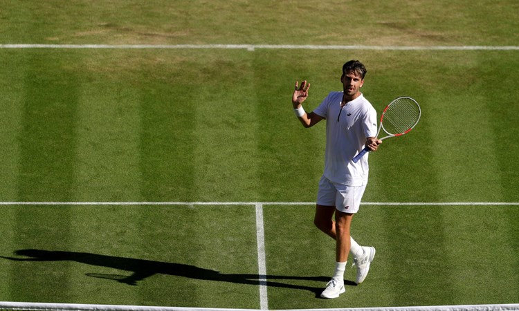 Cam Norrie gives a wave to the crowd on the grass at Wimbledon
