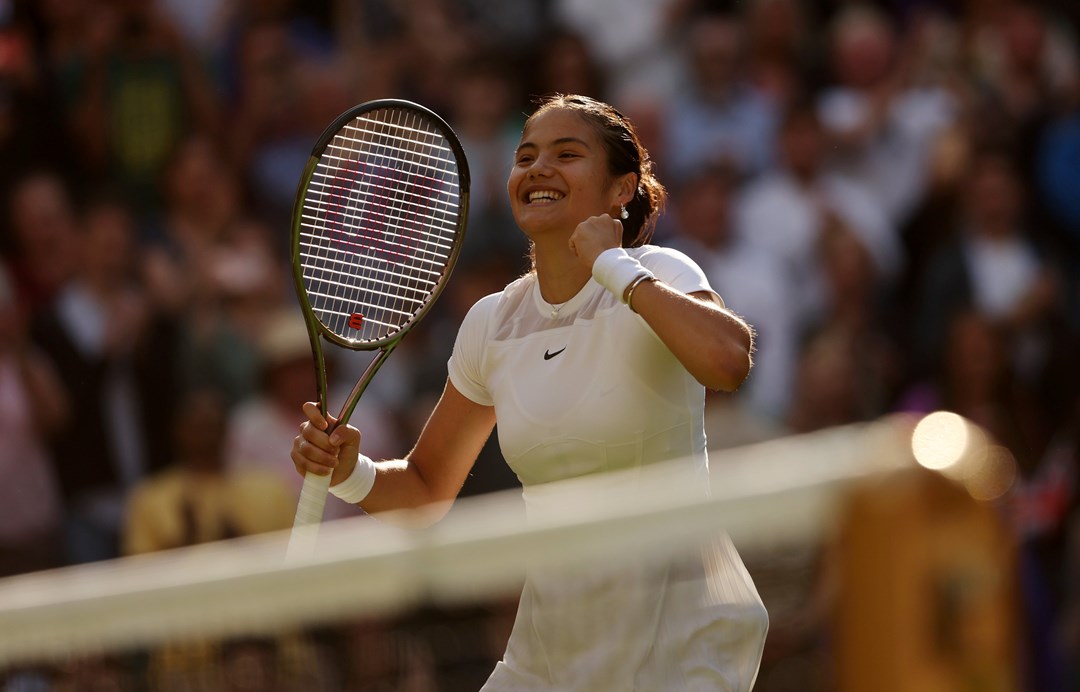 Emma Raducanu smiles in celebration after winning the opening round at Wimbledon 2022