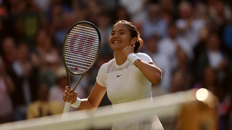 Emma Raducanu smiles in celebration after winning the opening round at Wimbledon 2022