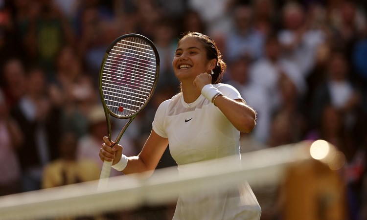 Emma Raducanu smiles in celebration after winning the opening round at Wimbledon 2022