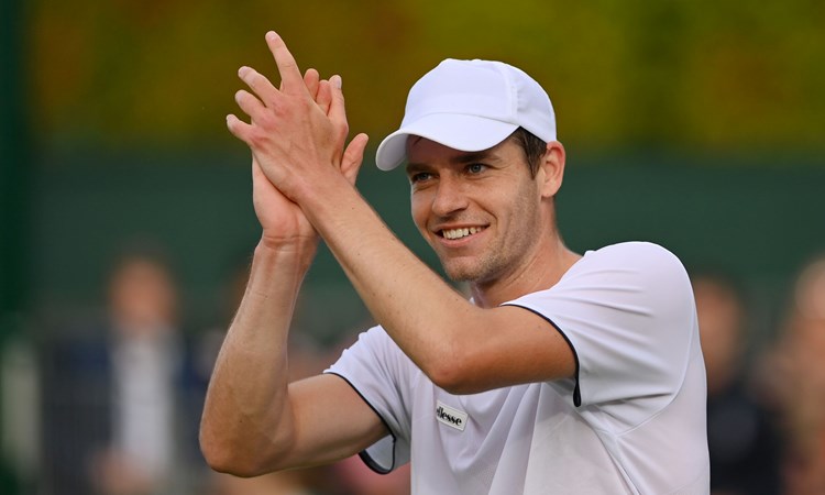 Alastair Gray applauds the crowd after winning on his Wimbledon debut