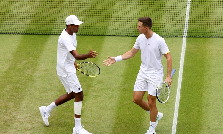 Joe Salisbury and Rajeev Ram high five in the Wimbledon quarter-finals