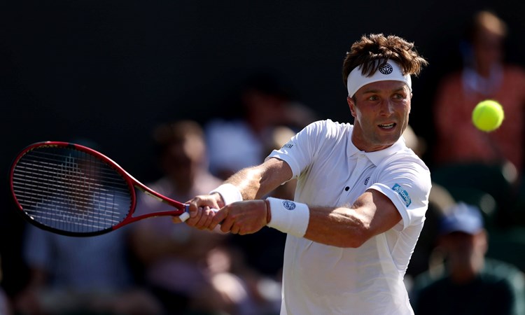 Liam Broady hits a backhand at Wimbledon 2023