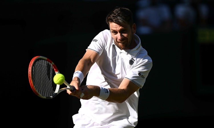 Cam Norrie hitting a backhand on court during his second round match at Wimbledon