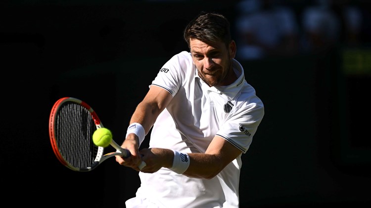 Cam Norrie hitting a backhand on court during his second round match at Wimbledon