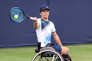 Greg Slade sat in his wheelchair hitting a forehand on a grass court 