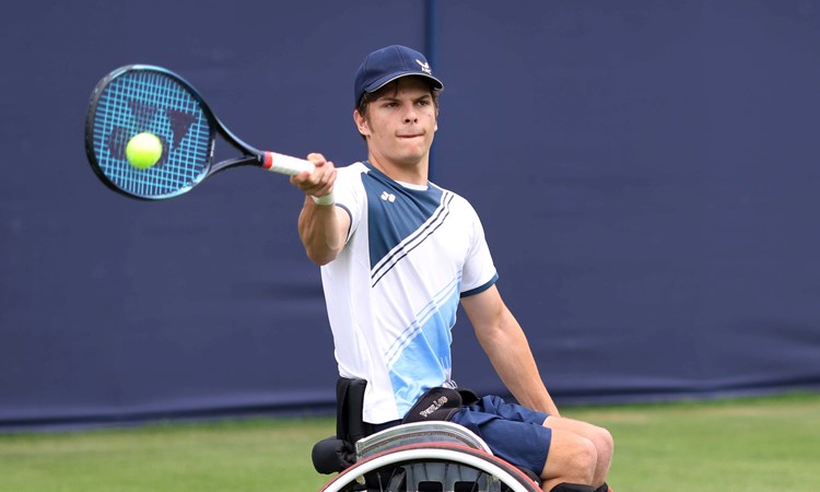 Greg Slade sat in his wheelchair hitting a forehand on a grass court 
