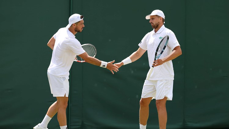 Julian Cash and Lloyd Glasspool high five in the quarter-finals at Wimbledon