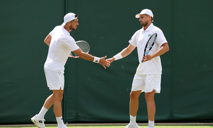 Julian Cash and Lloyd Glasspool high five in the quarter-finals at Wimbledon