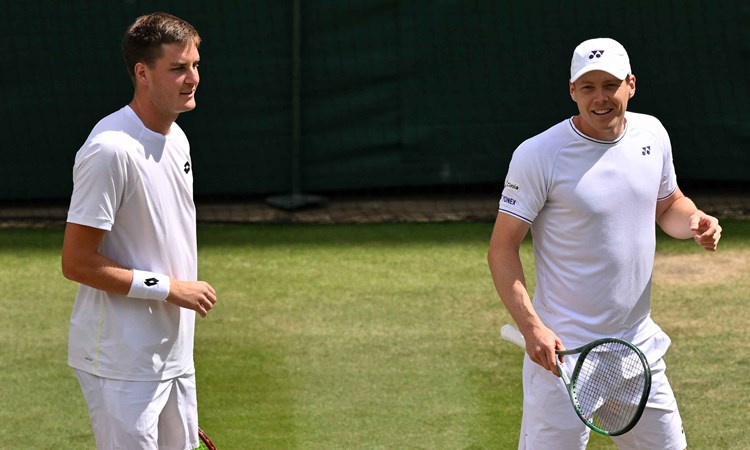 Henry Patten and Harri Heliovaara smiling on court at Wimbledon