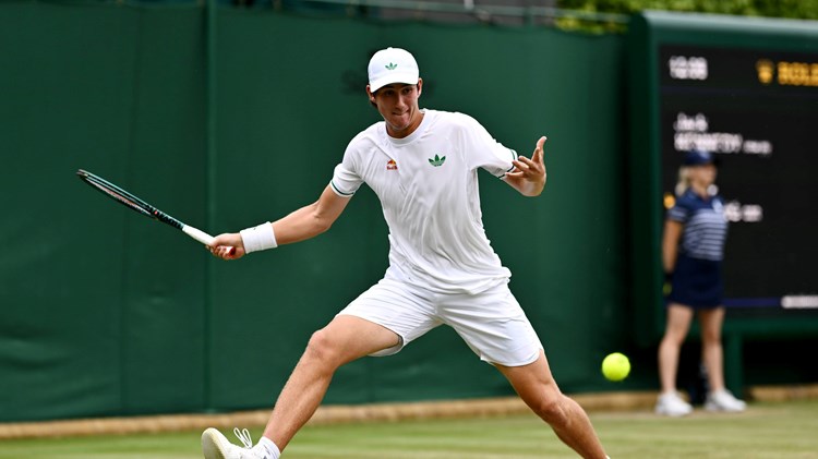 Oliver Bonding hitting a forehand on court at Wimbledon