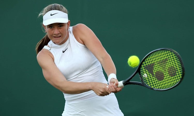 Mika Stojsavljevic hitting a backhand on court at Wimbledon