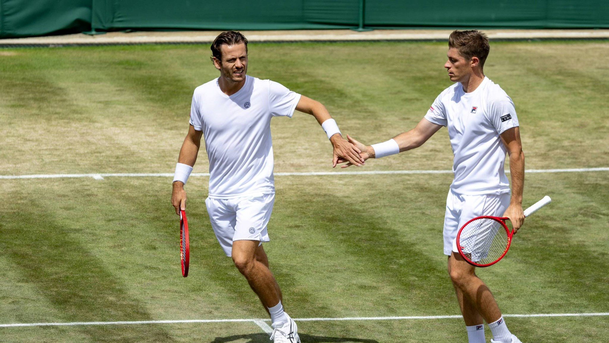 Neal Skupski and Wesley Koolhof high five in the Wimbledon men's doubles quarter-finals
