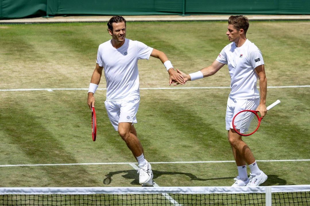 Neal Skupski and Wesley Koolhof high five in the Wimbledon men's doubles quarter-finals