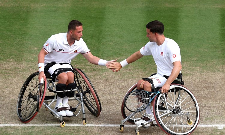 Alfie Hewett and Gordon Reid high five during doubles action at Wimbledon