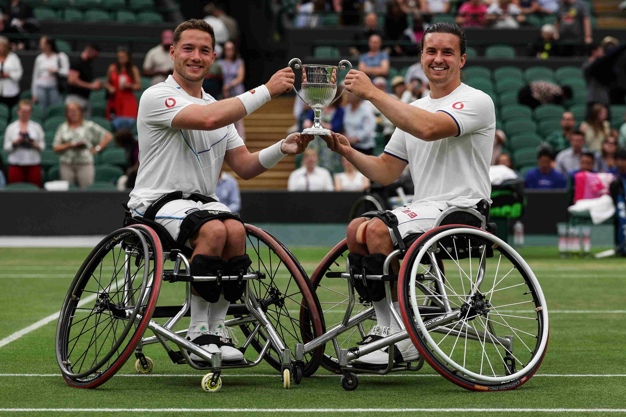 Alfie Hewett and Gordon Reid on court holding their men's wheelchair doubles trophy