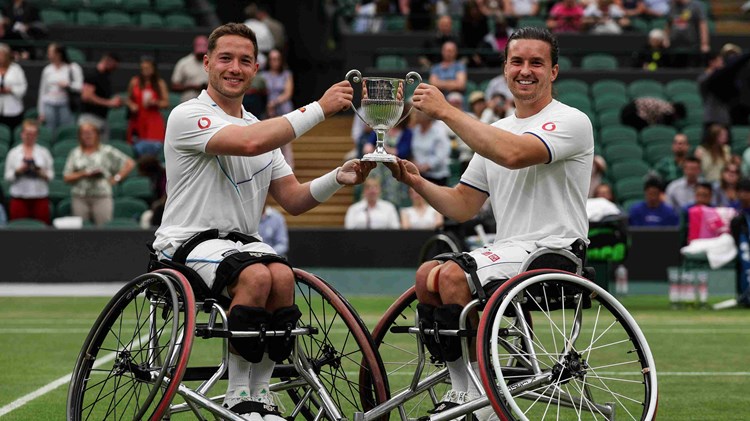 Alfie Hewett and Gordon Reid on court holding their men's wheelchair doubles trophy
