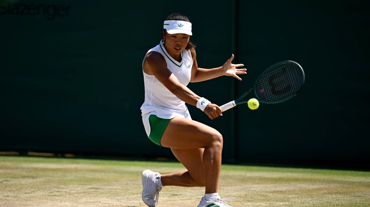 Mimi Xu hitting a backhand on the grass courts at Wimbledon