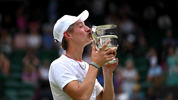 Henry Searle kissing his wimbledon juniors trophy