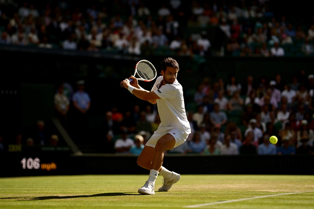 Cam Norrie about to hit a back hand in front of the Wimbledon crowd