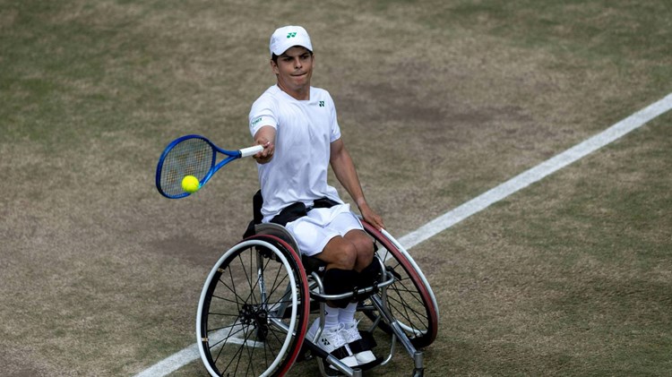 Greg Slade hitting a forehand on a grass court