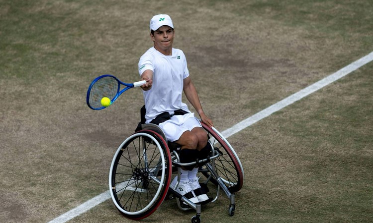 Greg Slade hitting a forehand on a grass court