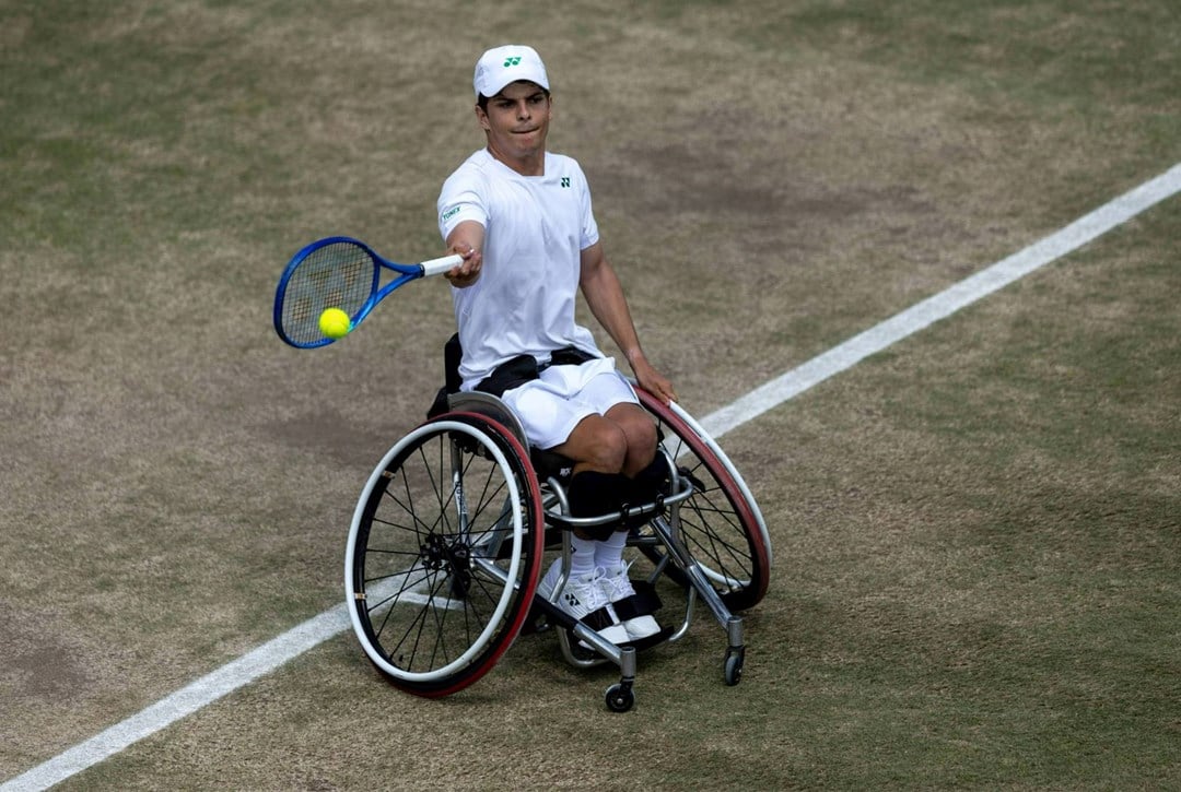 Greg Slade hitting a forehand on a grass court