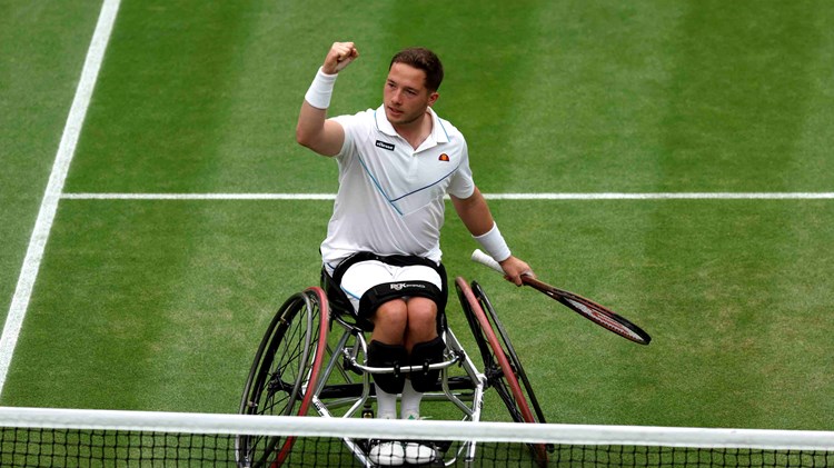 Alfie Hewett sat in his wheelchair on court, raising his fist in celebration