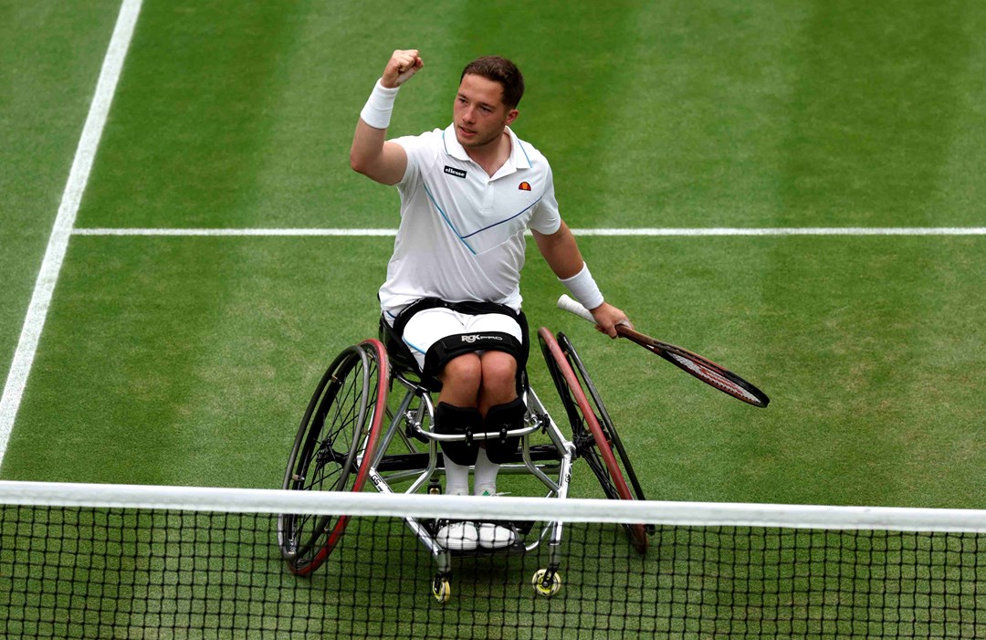 Alfie Hewett sat in his wheelchair on court, raising his fist in celebration