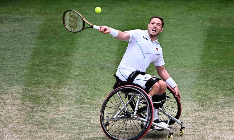 Alfie Hewett sitting in his wheelchair about to hit a forehand on court at the Wimbledon final