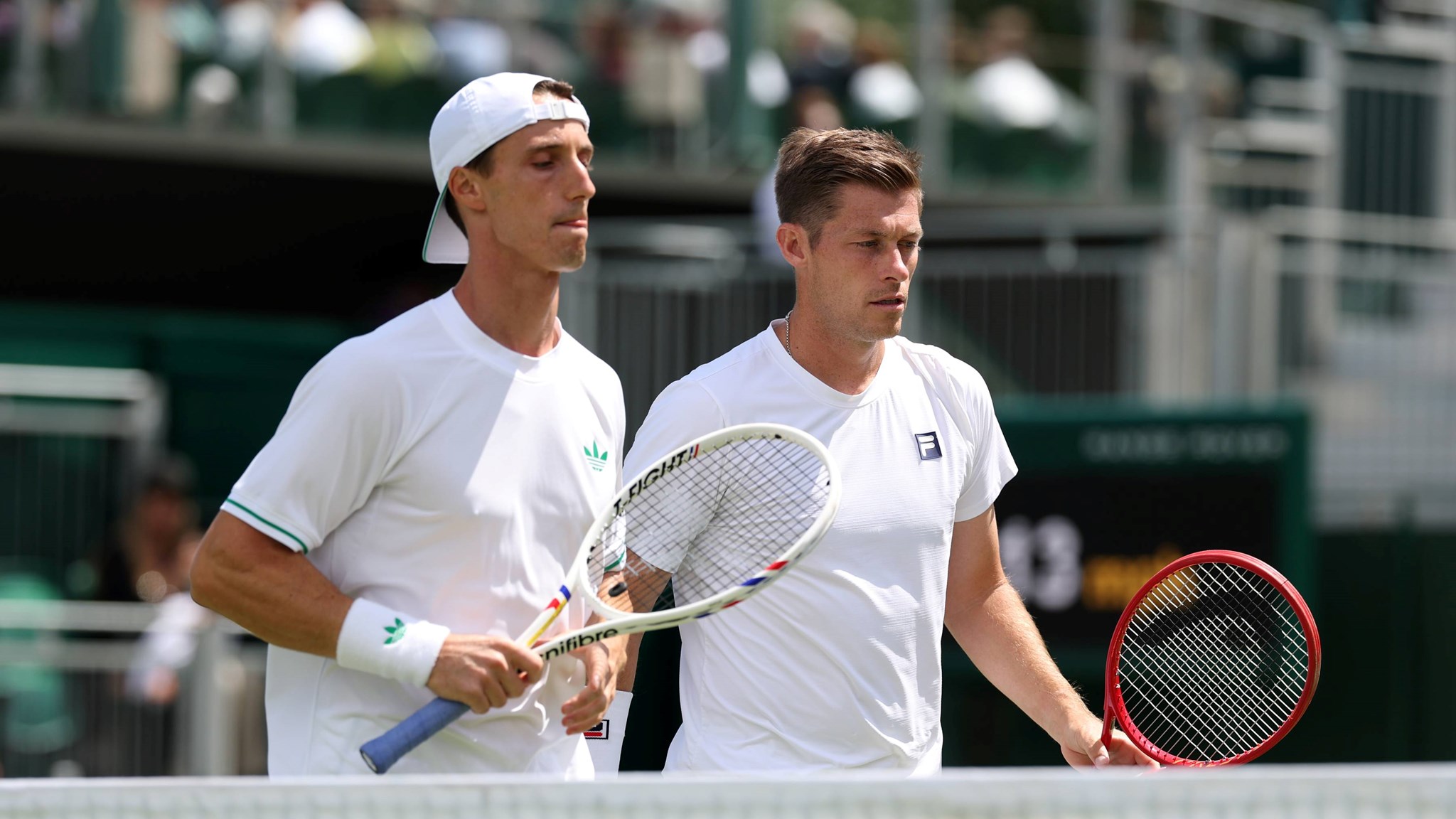Joe Salisbury and Neal Skupkski walk towards the net with their rackets in hand
