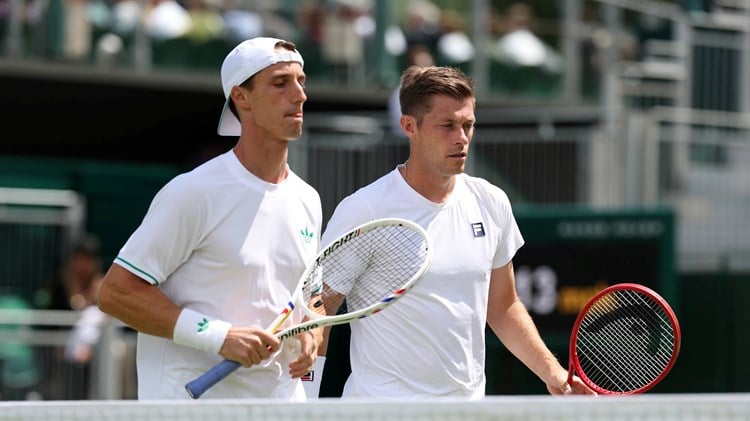 Joe Salisbury and Neal Skupkski walk towards the net with their rackets in hand